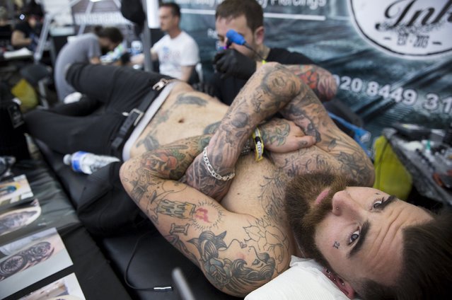A man is tattooed during the Great British Tattoo Show in Alexandra Palace in north London, Britain May 23, 2015. (Photo by Neil Hall/Reuters)