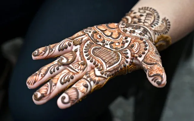A Kashmiri woman shows her hand decorated with henna at a market ahead of the Muslim festival of Eid al-Fitr in Srinagar on June 3, 2019. Muslims around the world are preparing to celebrate the Eid al-Fitr holiday, which marks the end of the fasting month of Ramadan. (Photo by Tauseef Mustafa/AFP Photo)