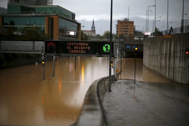 A view of a flooded highway access in Santiago April 17, 2016. The sign reads “Costanera highway closed to east”. (Photo by Ivan Alvarado/Reuters)