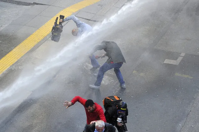 Media members run as riot police use water cannon to disperse protesters outside the Supreme Electoral Council (YSK) in Ankara April 1, 2014. Riot police fired water cannon in the Turkish capital on Tuesday to disperse thousands of people protesting outside the Supreme Electoral Council (YSK) against local election results which saw the ruling party dominate the electoral map. (Photo by Reuters/Stringer)