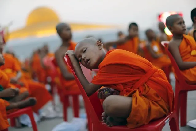A Buddhist monk sleeps on a chair while monks and novices gather to receive alms at Wat Phra Dhammakaya temple, in what organizers said was a meeting of over 100,000 monks in Pathum Thani, outside Bangkok, April 22, 2016. (Photo by Jorge Silva/Reuters)