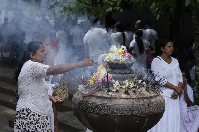 A Sri Lankan Buddhist devotee prays at a temple on the day of Buddha Poornima, or Vesak in Colombo, Sri Lanka, Thursday, May 23, 2023. In many parts of Asia, the sacred day marks not just the birth, but also the enlightenment and passing of the Buddha. (Photo by Eranga Jayawardena/AP Photo)