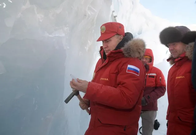 Russian President Vladimir Putin, center, and Prime Minister Dmitry Medvedev, right, inspect a cavity in a glacier on the Franz Josef Land archipelago in Arctic Russia, Wednesday, March 29, 2017. Russia has sought to strengthen its foothold in the Arctic amid intensifying rivalry for the region's rich natural resources between polar countries. (Photo by Alexei Druzhinin, Sputnik, Kremlin Pool Photo via AP Photo)