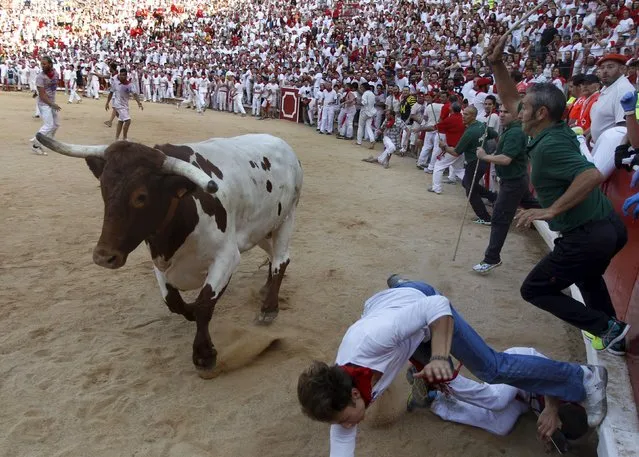 A runner dives to avoid a steer in the bullring following the first running of the bulls of the San Fermin festival in Pamplona, northern Spain, July 7, 2015. (Photo by Joseba Etxaburu/Reuters)