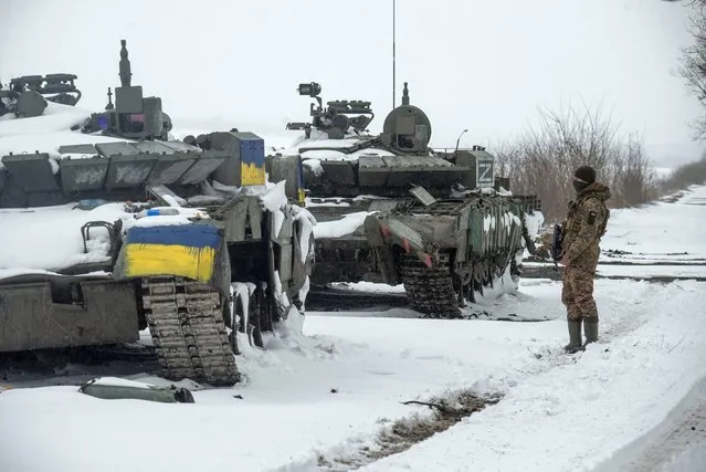 A Ukrainian serviceman stands near captured Russian tanks, one painted in the color of the Ukrainian national flag and the other marked with the letter “Z”, amid the Russian invasion of Ukraine, in the north of the Kharkiv region, Ukraine March 4, 2022. (Photo by Irina Rybakova/Press service of the Ukrainian Ground Forces/Handout via Reuters)