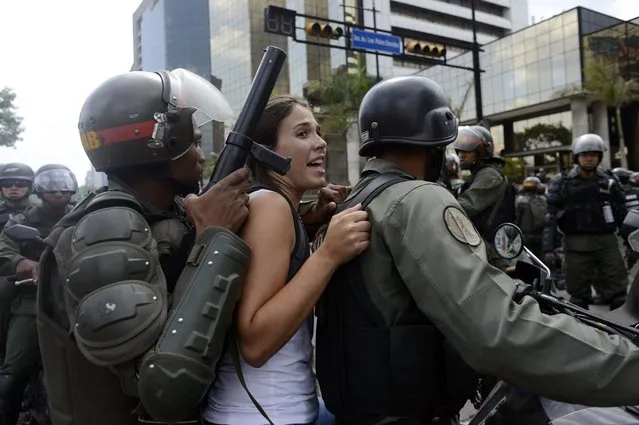 National Guard personnel in riot gear arrest students during an anti-government demonstration in Caracas on May 14, 2014. (Photo by Gerardo Caso/AFP Photo)
