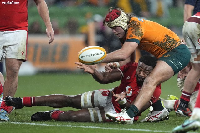 Wales' Christ Tshiunza, bottom, gets a pass away while under pressure from Australia's Fraser McReight during their rugby union test match in Melbourne, Saturday, July 13, 2024. (Photo by Asanka Brendon Ratnayake/AP Photo)