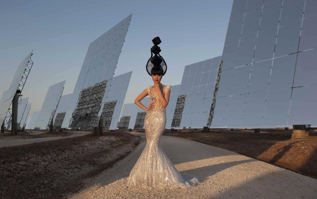 Jessica Minh Anh poses with a Vietnamese dress design by Hoang Hai during the J Summer Fashion show at the Gemasolar solar plant outside Seville, Spain, Friday July 17, 2015. Billed as the World's first ever solar powered catwalk, model and entrepreneur Jessica Minh Anh, chose the Gemasolar solar plant for her latest unconventional display after organising catwalks on the Eiffel Tower, One World Trade Center, London's Tower Bridge, and the PETRONAS Twin Towers' Skybridge. (Photo by Laura Leon/AP Photo)