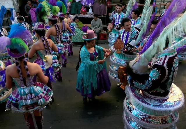 A woman gices a drink to Morenada dancers during the “Senor del Gran Poder” (Lord of Great Power) parade in La Paz, May 21, 2016. (Photo by David Mercado/Reuters)