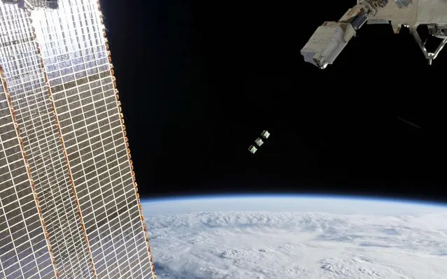 This NASA photo obtained released June 19, 2019 shows a set of three CubeSats pictured shortly after being ejected from the Japanese Small Satellite Orbital Deployer attached to a robotic arm outside of the Japan Aerospace Exploration Agency's Kibo laboratory module on June 17, 2019. The tiny satellites from Nepal, Sri Lanka and Japan were released into Earth orbit for technology demonstrations.The International Space Station was orbiting 256 miles above the Amazon River in Brazil when an Expedition 59 crewmember took this photograph. (Photo by Handout/NASA/AFP Photo)