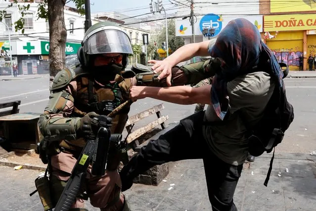 A demonstrator scuffles with a riot police officer during a protest against Chile's government in Valparaiso, Chile on November 12, 2019. (Photo by Rodrigo Garrido/Reuters)