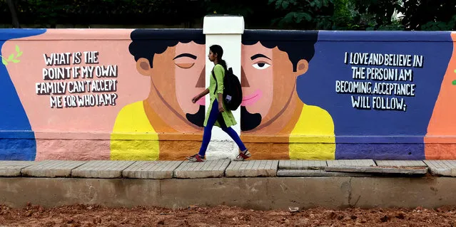 An Indian walks next to a painting on a roadside wall in Bangalore, India, 18 September 2019. Around 250 artists painted the walls with different vibrant color to create awareness about suicide prevention and mental health among people, as part of the World Suicide Prevention Day. (Photo by Jagadeesh N.V./EPA/EFE)