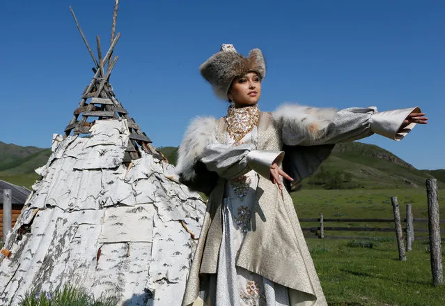 A model of the “Altyr” fashion theatre, dressed in a Khakas traditional bride's costume, poses near a wedding birchbark yurta during a photo session, as a part of the rehearsal for the Tun-Pairam traditional holiday (The Holiday of the First Milk) celebration at a museum preserve outside Kazanovka village near Abakan in the Republic of Khakassia, Russia, May 28, 2016. (Photo by Ilya Naymushin/Reuters)