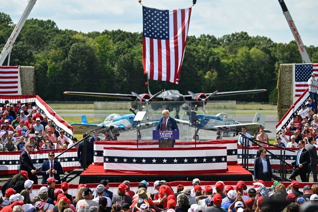 Former US President and Republican presidential candidate Donald Trump speaks behind bulletproof glass during a campaign rally at the North Carolina Aviation Museum & Hall of Fame in Asheboro, North Carolina, August 21, 2024. (Photo by Peter Zay/AFP Photo)