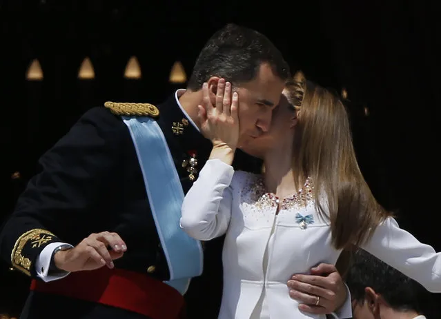Spain’s newly crowned King Felipe VI is kissed by his wife Queen Letizia on a balcony of the Royal Palace in Madrid, Spain, on Thursday, June 19, 2014. Felipe is being formally proclaimed monarch Thursday after 76-year-old King Juan Carlos abdicated so that younger royal blood can rally a country beset by economic problems, including an unemployment rate of 25 percent. Felipe swore an oath at a ceremony with lawmakers in Parliament in front of Spain's 18th-century crown and 17th-century scepter. (Photo by Emilio Morenatti/AP Photo)