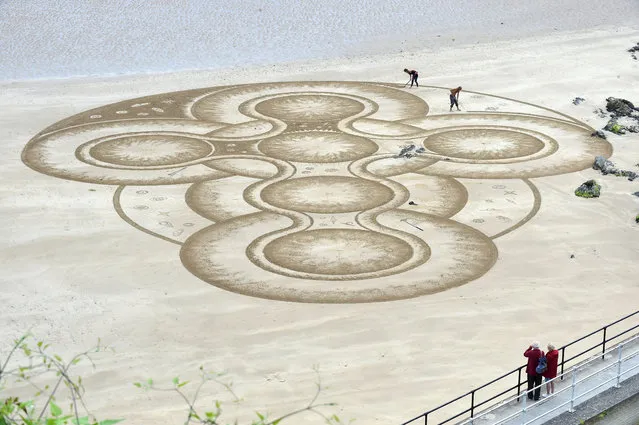 Sand artist Marc Treanor creates a work on the North Beach at Tenby Harbour, Pembrokeshire, Wales, Britain June 7, 2017. (Photo by Rebecca Naden/Reuters)