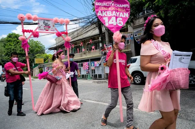 Women wearing gowns walk alonng the streets during a Santacruzan-themed house-to-house campaign for Philippine Vice President and presidential candidate Leni Robredo, in Quezon City, Metro Manila, Philippines on May 5, 2022. (Photo by Lisa Marie David/Reuters)