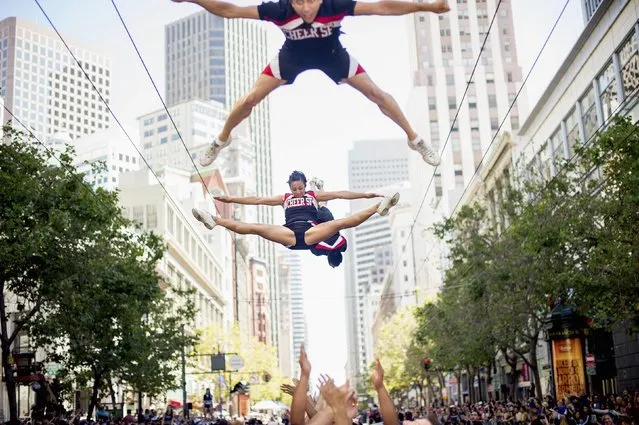 Members of cheerleading team CHEER SF soar above Market Street during the San Francisco Gay Pride Festival in California June 29, 2014. (Photo by Noah Berger/Reuters)
