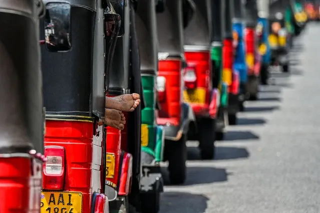 Autorickshaws are parked in a queue along a street to tank up petrol from a Ceylon petroleum corporation fuel station in Colombo on June 20, 2022. (Photo by Ishara S. Kodikara/AFP Photo)