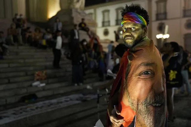 A demonstrator dons a flag emblazoned with the image of Brazil's former president and current presidential candidate Luiz Inacio Lula da Silva, during an International LGBT + Pride Day, in Rio de Janeiro, Brazil, Tuesday, June 28, 2022, marking the anniversary of the Stonewall uprisings, when patrons of a Greenwich Village gay bar fought back against a police raid and sparked a new era of gay activism. (Photo by Silvia Izquierdo/AP Photo)