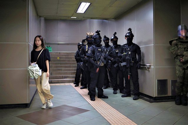 A woman walks past South Korean soldiers taking part in an anti-terror drill as part of the annual Ulchi Freedom Shield joint military exercise between South Korea and U.S., at a subway station in Seoul, South Korea on August 22, 2023. (Photo by Kim Hong-Ji/Reuters)