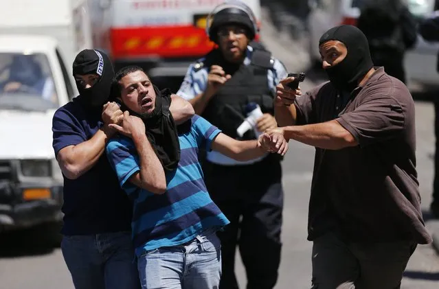 An undercover Israeli police officer holds a gun in the air as another detains a Palestinian suspected of throwing stones in the East Jerusalem neighbourhood of Wadi al-Joz during a protest against the Israeli offensive on Gaza August 1, 2014. Israel declared a Gaza ceasefire over on Friday, saying Hamas militants breached the truce soon after it came in effect and apparently captured an Israeli officer while killing two other soldiers. (Photo by Ammar Awad/Reuters)