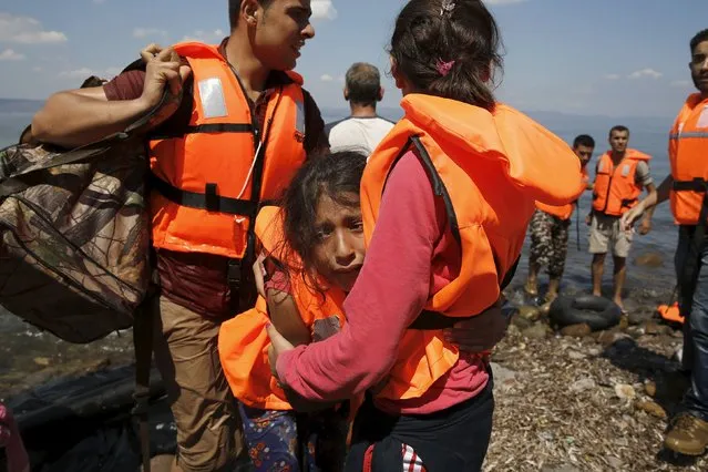 A Syrian refugee girl from Kobani cries as she hugs her mother, moments after arriving with other Syrian refugees on a dinghy on the island of Lesbos, Greece August 23, 2015. (Photo by Alkis Konstantinidis/Reuters)
