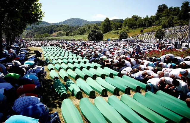 Muslim men pray in front of coffins during mass funeral in Potocari near Srebrenica, Bosnia and Herzegovina July 11, 2016. (Photo by Dado Ruvic/Reuters)