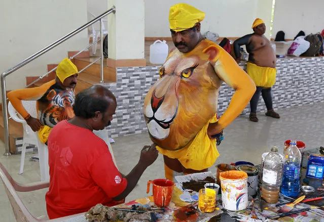 A performer has his body painted to look like a lion before he takes part in the festivities marking the start of the annual harvest festival of Onam in Kochi, India August 25, 2017. (Photo by Sivaram V/Reuters)
