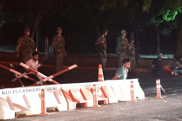 Turkish security officers detain police officers on the side of the road on July 15, 2016 in Istanbul, during a security shutdown of the Bosphorus Bridge. Turkish Prime Minister Binali Yildirim on July 15 denounced what he said was an “illegal attempt” by elements in the military after bridges were partially shut down in Istanbul and jets flew low over Ankara. “We are working on the possibility of an attempt. We will not allow this attempt”, he told NTV television by telephone, without expanding on the nature of the move but saying it was by a group in the Turkish military. (Photo by Bulent Kilic/AFP Photo)