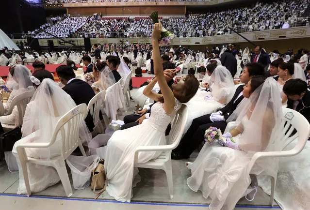 A bride takes pictures during a mass wedding ceremony at the Cheong Shim Peace World Center in Gapyeong, South Korea, Thursday, September 7, 2017. (Photo by Ahn Young-joon/AP Photo)