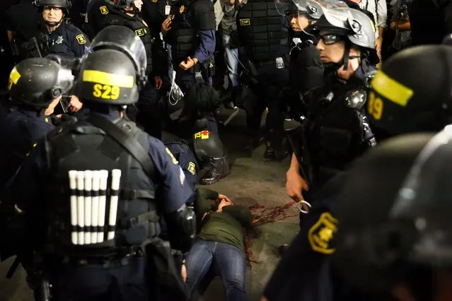 Police officers surround a supporter of conservative commentator Ben Shapiro after she took a fall to the ground following a speech by Shapiro, September 14, 2017 at the University of California, Berkeley. (Photo by Elijah Nouvelage/AFP Photo)