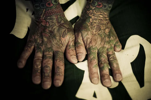 Tattooed hands with a digit missing. A traditional Japanese tattoo, as used often by the Yakuza, Is a very old and time-consuming process of manually sticking a stick with at the point several sharp inked needles in the skin. This has to happen at a precise angle (depending on skin thickness) and at a precise speed (120/minute), and this is a skill that only traditional Japanese tattoo masters possess. (Photo and caption by Anton Kusters)