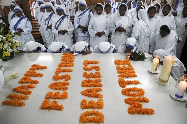 Roman Catholic nuns of the Missionaries of Charity order attend a service to commemorate the 17th death anniversary of Mother Teresa at her tomb at the Missionaries of Charity house in Kolkata on September 5, 2014. Mother Teresa, “Angel of Mercy”, Nobel peace prize winner and Roman Catholic saint-in-waiting died on September 5, 1997 in the eastern city of Kolkata. (Photo by Dibyangshu Sarkar/AFP Photo)