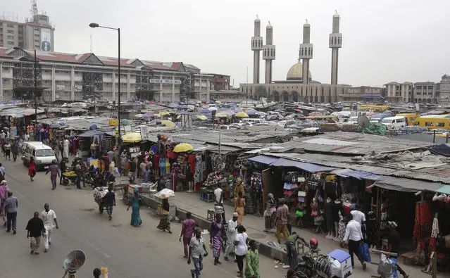 In this photo taken Friday July 1, 2016, pedestrians shop on the streets near the central mosque in Lagos, Nigeria. Officials in Nigeria's biggest city are closing down dozens of churches, mosques and nightclubs in a bid to reduce noise in Lagos, the seaside commercial center where honking horns and thrumming generators compete with lusty hymn-singing and loudspeakers calling people to prayer. (Photo by Sunday Alamba/AP Photo)