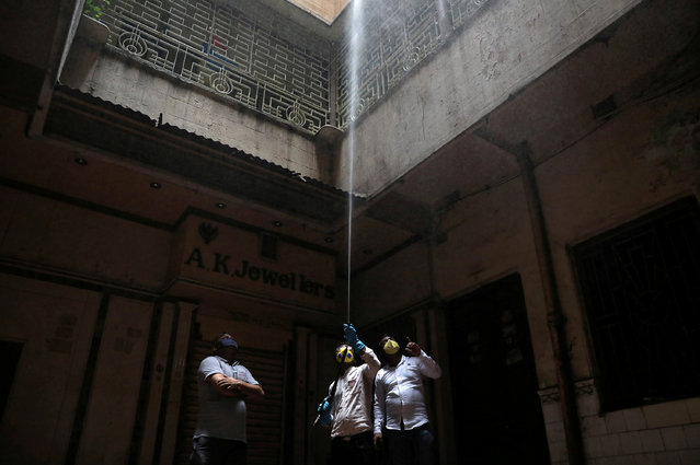 Municipal workers decontaminate a market area during an extended nationwide lockdown to slow the spreading of coronavirus disease (COVID-19) in Kolkata, India, April 26, 2020. (Photo by Rupak De Chowdhuri/Reuters)