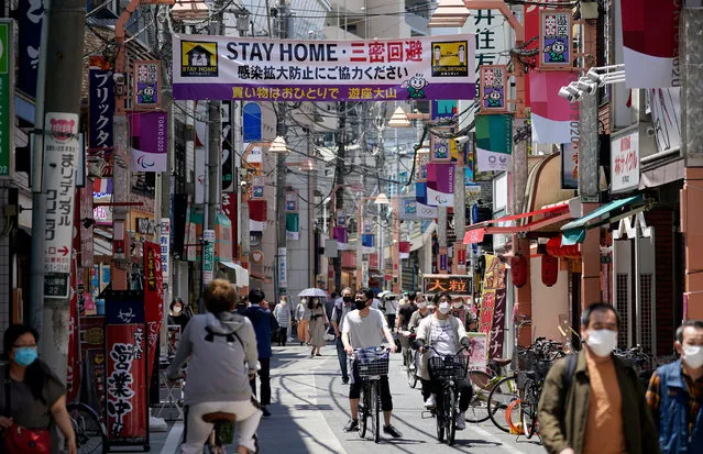 A banner calls for people to stay at home to contain the spread of the COVID-19 and coronavirus pandemic at a shopping street in Tokyo, Japan, 11 May 2020. Earlier in the month, Japanese Prime Minister Shinzo Abe extended the state of emergency through the end of May but the government may lift the emergency declaration in prefectures that have recorded less infections in the past days. (Photo by Franck Robichon/EPA/EFE)