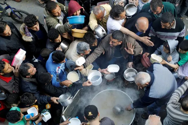Palestinians gather to get soup offered for free during the Muslim fasting month of Ramadan, amid concerns about the spread of the coronavirus disease (COVID-19), in Gaza City on April 26, 2020. (Photo by Suhaib Salem/Reuters)
