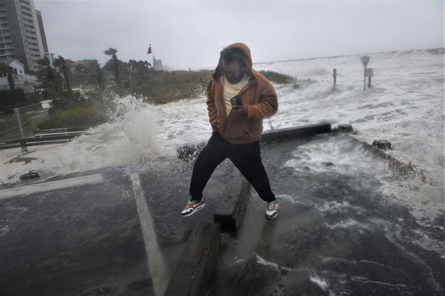 John Ramirez reacts to water splashing toward him as Hurricane Ian effects the coast in Myrtle Beach, SC on September 30, 2022. (Photo by Melissa Sue Gerrits for The Washington Post)