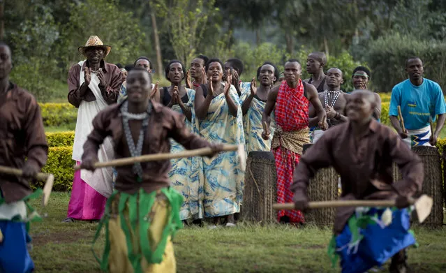 In this photo taken Friday, September 4, 2015, traditional dancers entertain tourists prior to them being briefed by park rangers before their trek to see the mountain gorillas in Volcanoes National Park, northern Rwanda. (Photo by Ben Curtis/AP Photo)
