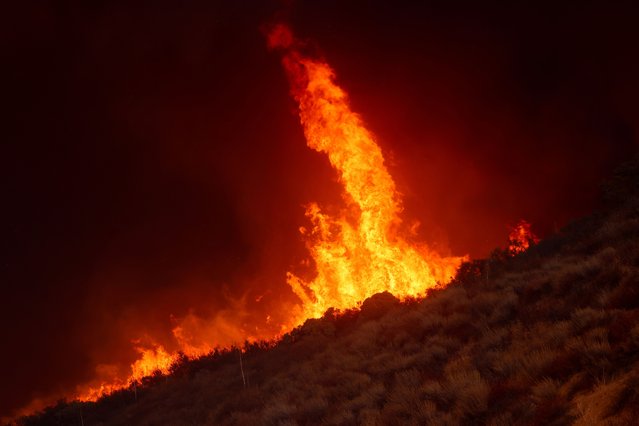 Flames rise while firefighters battle the Hughes Fire near Castaic Lake, north of Santa Clarita, California, on January 22, 2025. (Photo by David Swanson/Reuters)