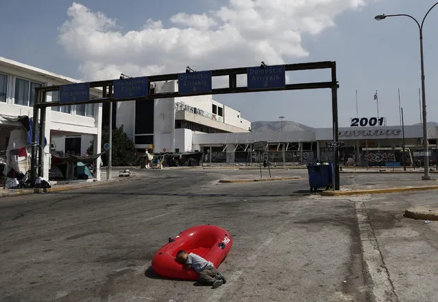 An Afghan boy lies on a plastic boat at the outdoor area of the abandoned former Athens international airport, were refugees and migrants found temporary shelter, in Athens, Greece, 23 August 2016. The United Nations high commissioner for refugees, Filippo Grandi, will start a three-day visit to Athens on Tuesday to assess the humanitarian needs of the refugees and migrants hosted in Greece and find ways to help the country tackle the issue. (Photo by Yannis Kolesidis/EPA)