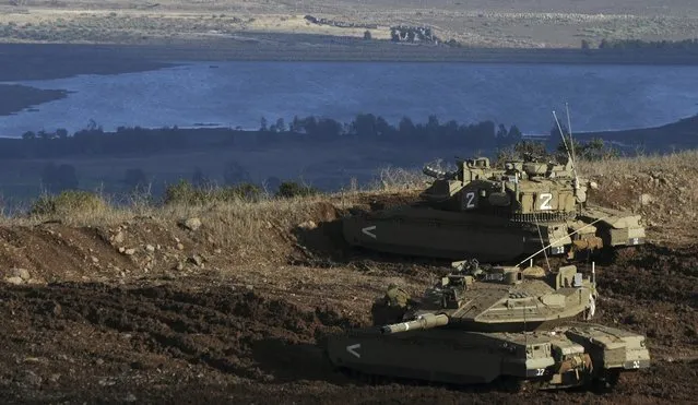 Israeli tanks stand in position overlooking a Syrian village from the Israeli-occupied Golan Heights, November 12, 2012. (Photo by IDF)
