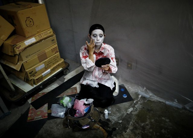 Actor Ayaka Imaide prepares zombie makeup before her performance at a drive-in haunted house show in Tokyo, Japan on July 3, 2020. The performance group Kowagarasetai - which roughly translates as the “scare squad” – is hoping to frighten as many as 11 carloads of people a day at weekends in July and hopefully August, coordinator Kenta Iawana said. Each group will pay up to 9,000 yen ($84) for the experience, he added. Shows last for about 15 minutes until the shutter goes up and another group comes in, and customers without a car can borrow one. (Photo by Issei Kato/Reuters)