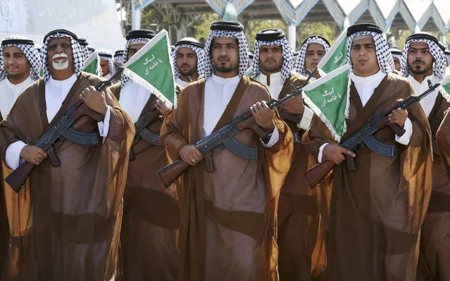 Iranian Arabs who are members of the paramilitary Basij force march in a military parade marking the 35th anniversary of Iraq's 1980 invasion of Iran, in front of the shrine of late revolutionary founder Ayatollah Khomeini, just outside Tehran, Iran, Tuesday, September 22, 2015. (Photo by Vahid Salemi/AP Photo)