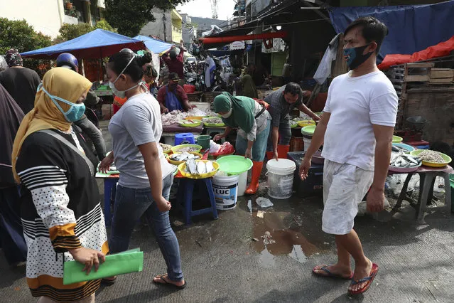 People wear face masks as a precaution against the new coronavirus at a market in Jakarta, Indonesia, Wednesday, June 24, 2020. (Photo by Achmad Ibrahim/AP Photo)