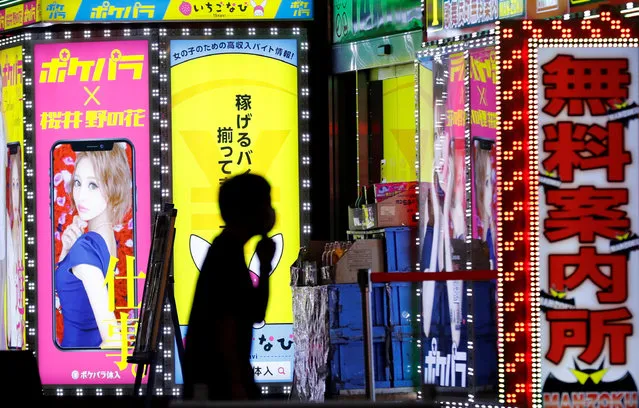 A man wearing a face mask walks past a signboard of a bar in the Kabukicho district, amid the coronavirus disease (COVID-19) outbreak in Tokyo, Japan, July 14, 2020. (Photo by Kim Kyung-Hoon/Reuters)
