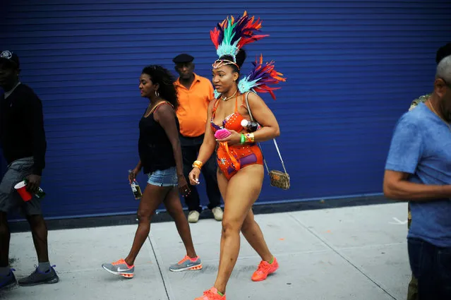 A woman walks through the street towards the starting location of the annual West Indian-American Carnival Day Parade in Brooklyn, NY, U.S. September 5, 2016. (Photo by Mark Kauzlarich/Reuters)