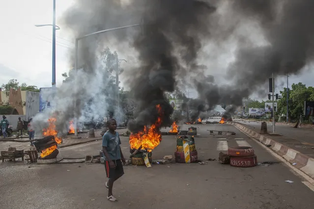 Anti-government protesters burn tires and barricade roads in the capital Bamako, Mali, Friday, July 10, 2020. Thousands marched Friday in Mali's capital in anti-government demonstrations urged by an opposition group that rejects the president's promises of reforms. (Photo by Baba Ahmed/AP Photo)