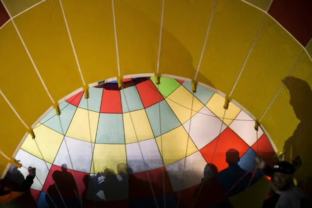Shadows of attendees are seen inside a hot air balloon as it is prepared for take off on the first day of the 2015 Albuquerque International Balloon Fiesta in Albuquerque, New Mexico, October 3, 2015. (Photo by Lucas Jackson/Reuters)